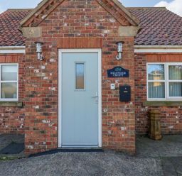 A front entrance with a door and windows at Heather Croft in Robin Hood's Bay