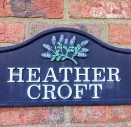 A nameplate on a brick wall at Heather Croft in Robin Hood's Bay
