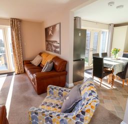 A living room with a sofa and dining area at Heather Croft in Robin Hood's Bay