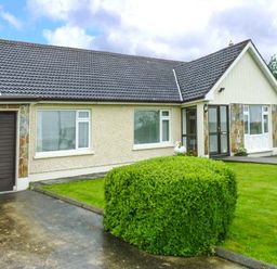 A bungalow with a driveway and trimmed bush in front at Eileen's Aughavas near Mohill County Leitrim
