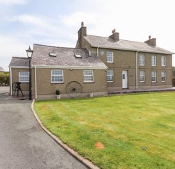 A detached house with multiple windows a lawn and a driveway at Garreg Wen Isaf Bach in Penygroes near Caernarfon