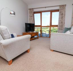 A living room with a sofa and television at Pound Cottage in Huntshaw near Great Torrington