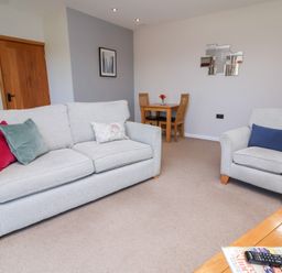 A living room with a sofa and armchair at Pound Cottage Huntshaw near Great Torrington