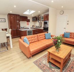 A living room with sofa and dining area at Beech Hill Lodge (Beech Hill 9) at Fallbarrow Park, Bowness-on-Windermere