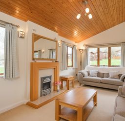 A living room with sofas coffee table fireplace and large windows at High Tide in Rock