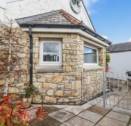 An outdoor area with a stone wall and window at Chapel Green Studio 2 in Polgooth