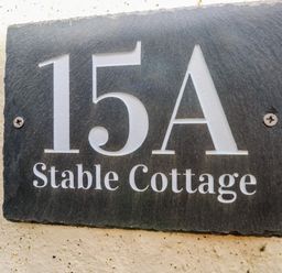 A house number plaque with 15A Stable Cottage on a wall at Stable Cottage in Pembroke