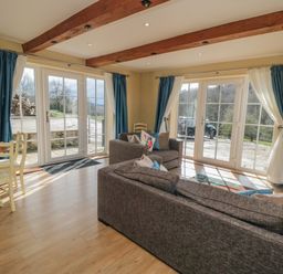 A sitting room with sofas dining table large windows and visible outdoor area at Ericas eaven in Farndale near Kirkbymoorside