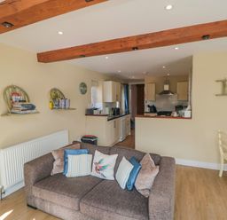 A living room with a sofa and cushions near an open kitchen and dining area at Ericas eaven in Farndale near Kirkbymoorside
