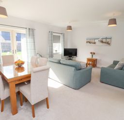 A living room with a TV and a dining area at The Haven in Embleton