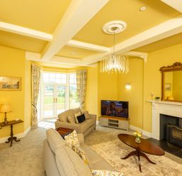 A living room with sofas coffee table fireplace and television at Old Rectory House Caersws