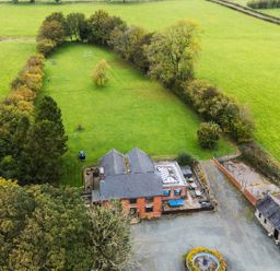 An outdoor view of a house with a garden and pool at Ty Newydd in Llangadfan