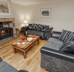 A living room with a fireplace and sofas at High Hemmel House in Embleton