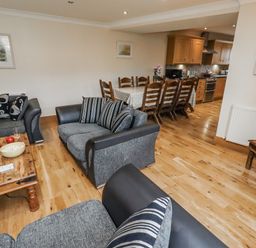 A living room with a dining area and kitchen at High Hemmel House in Embleton