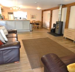 A living room with sofas, a television, and a fireplace at Kingfisher in Blaenwaun