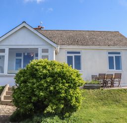 A house with a garden and outdoor seating at Highdown in Bigbury on Sea near Modbury