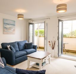 A living room with blue sofas and a white coffee table with drawers at Stone's Throw in Charlestown