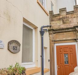 The entrance of a building with a wooden door a rain gutter two signs reading Mayfield Manor 57 and a textured glass window at Mayfield Manor Whitby