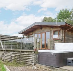 An outdoor area with a wooden cabin and hot tub at The Cabin Pontardawe