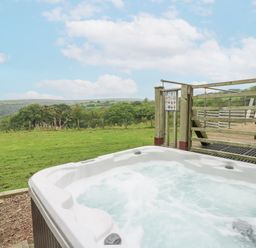 An outdoor hot tub with a view of the landscape at The Cabin in Pontardawe