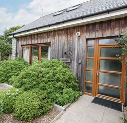 A house with a wooden exterior and pathway at Budmouth Upwey near Weymouth