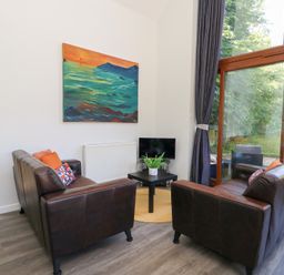 A living room with sofas and a television at Shepherd Oak in Upwey near Weymouth