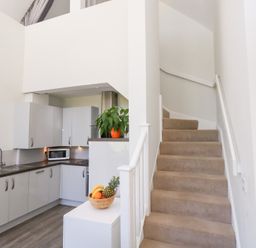 A kitchen with a staircase at Shepherd Oak in Upwey near Weymouth
