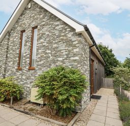 Exterior view of a house with stone wall and bushes at Everdene Upwey near Weymouth
