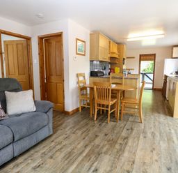 A kitchen with dining table and chairs at Dragonfly Lodge in Whinburgh near Dereham
