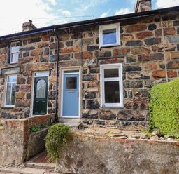 Stone terraced houses with blue and green doors and small front gardens in Nantmel Beddgelert
