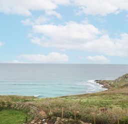 A view of the ocean with clouds and land at The Coach House in Sennen near St Just