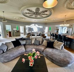 A living room with a large sofa and a bar counter at Capel Mawr in Llanrug near Llanberis