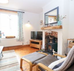 A living room with a television and fireplace at Driftwood Cottage Heacham