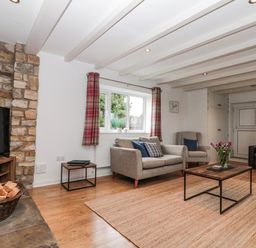 A living room with a television and coffee table at Wold Cottage in Hunmanby