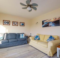 A living room with sofas and artwork at Merlin's Retreat in Tintagel