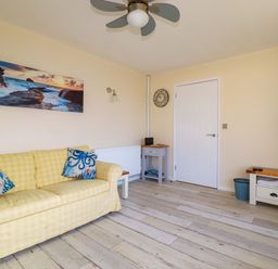 A living room with a sofa and television at Merlin's Retreat in Tintagel