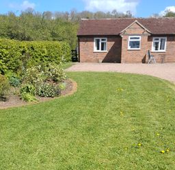 A house with a garden and pathway at Lawn Lodge in Ashleworth