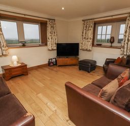 A living room with sofas and a television at Long Cart Cottage Embleton