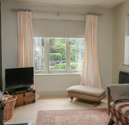 A living room with a television and an ottoman at Gable End in Coniston near Hawkshead