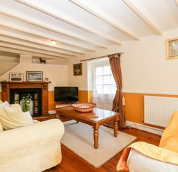 A living room with two sofas a wooden coffee table and a fireplace at The Pound in Trellech near Monmouth