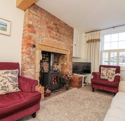 A living room with a fireplace and a sofa at Croft View Fylingthorpe near Robin Hood's Bay