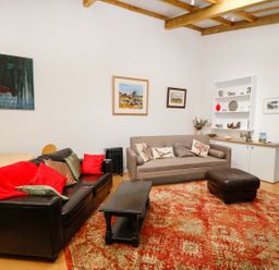 A living room with sofas, a coffee table, round dining table, and paintings on the wall at View The Gallery in Okehampton