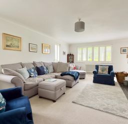 A living room with a sofa and armchair at Kilcarreg in Rock near Wadebridge