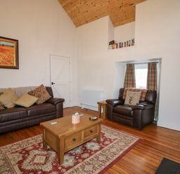 A living room with sofa and coffee table at Rosslare Cottage Broughshane