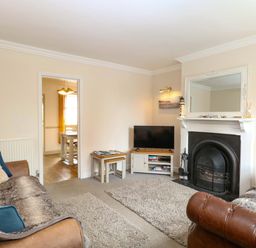 A living room with sofas and a television at Fern Cottage in Heacham