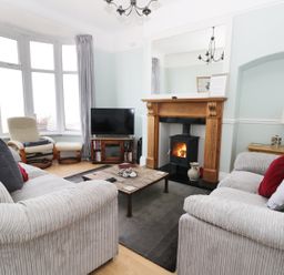 A living room with two sofas a wooden coffee table a fireplace a television and an armchair at Number Fifteen in Withernsea