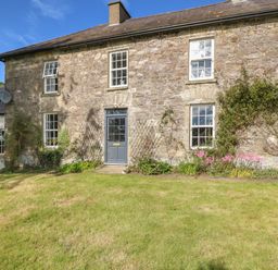 Stone house exterior with blue door and multiple windows and garden in front at Ballintlea Ballintlea near Dungarvan County Waterford