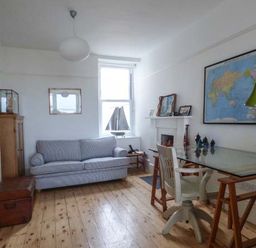 A room with a sofa desk chair and a world map on the wall at Sandy Bank in Rhosneigr