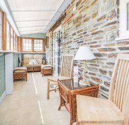 A conservatory with seating and tables at Dovecote in Gorran Haven