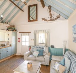 A living room with a sofa and coffee table at Dovecote in Gorran Haven